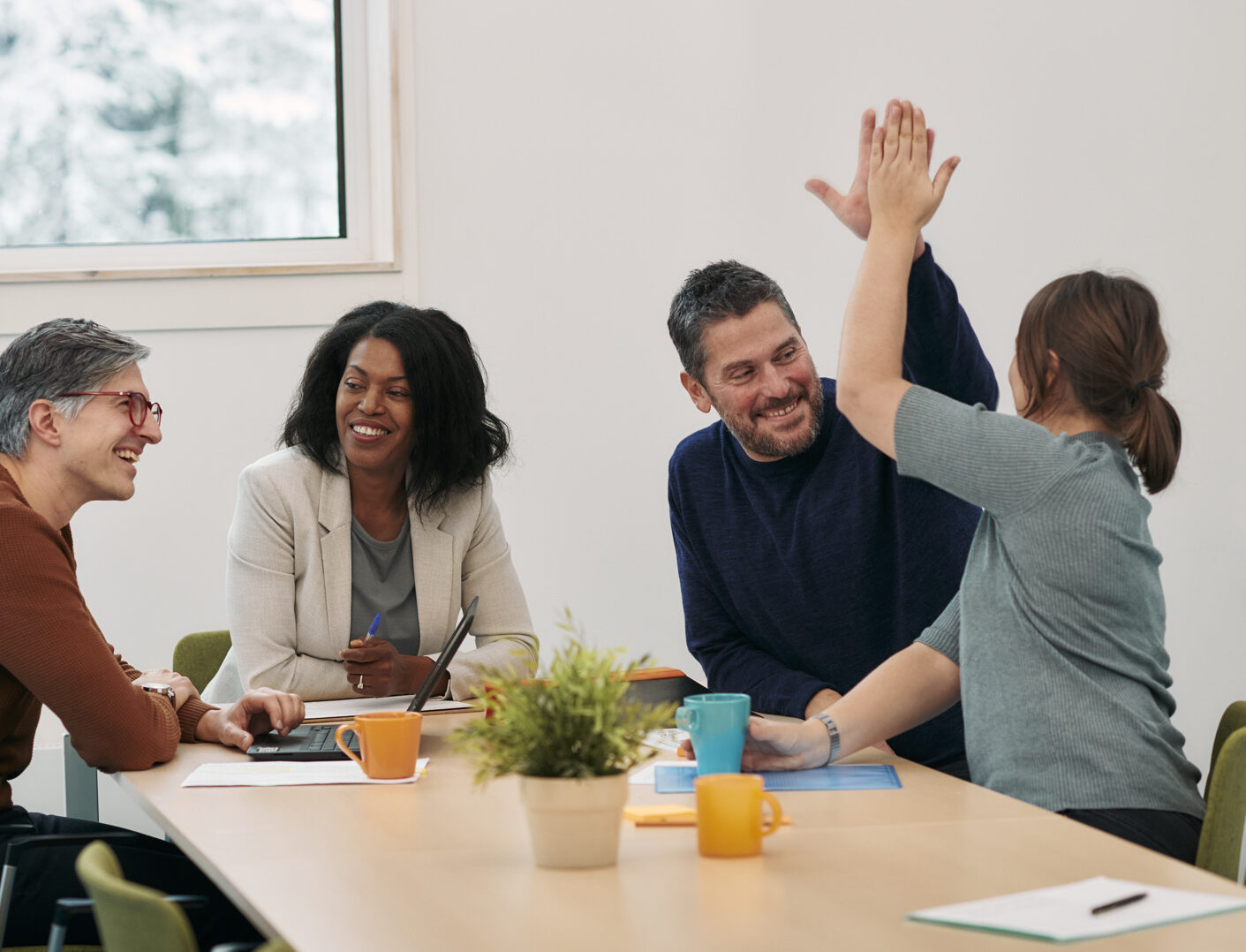 En arbetsgrupp där två personer gör high five.